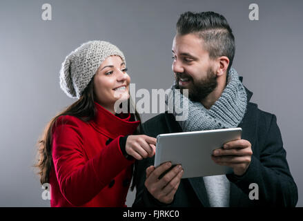 Young woman and man in winter coats with tablet Stock Photo