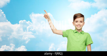 happy boy in green polo t-shirt pointing finger up Stock Photo