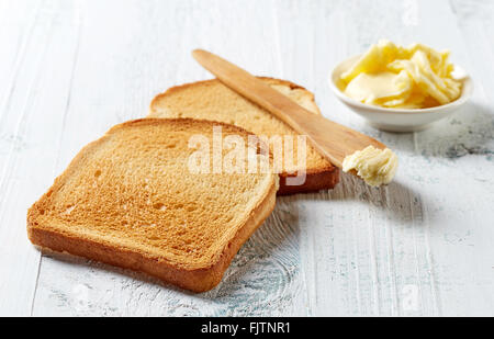 Slices of toast bread and butter on wooden table Stock Photo