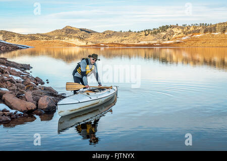 senior male paddler with his decked expedition canoe on a shore  of Horsetooth Reservoir near Fort Collins in northern Colorado, Stock Photo