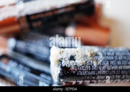 Old alkaline household batteries leak a white crusty substance made of potassium carbonate (K2CO3) Stock Photo