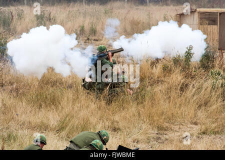 England. War and Peace Show. Re-enactment of Vietnam battle. American kneeling in field, firing rocket propelled grenade at unseen Viet-con troops. Stock Photo