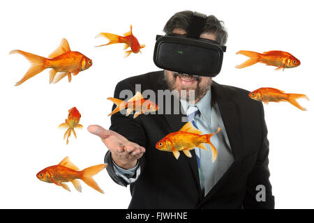 Businessman using virtual reality glasses with goldfish swimming Stock Photo
