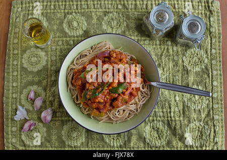 A bowl of pasta with garlic and herbs on the side. Stock Photo