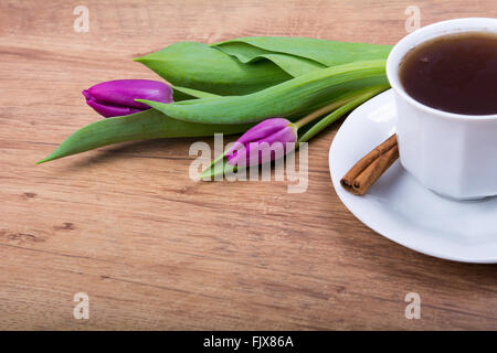 A cup of tea with cinnamon and purple tulips Stock Photo - Alamy