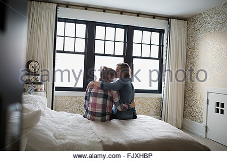 Mother hugging and kissing teenage daughter in bedroom Mother hugging and kissing teenage daughter in bedroom