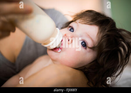 Cute baby being bottle fed by his mother Stock Photo