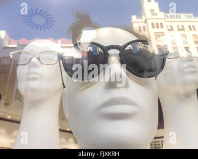 Three mannequin heads in shop window with urban reflections Stock Photo