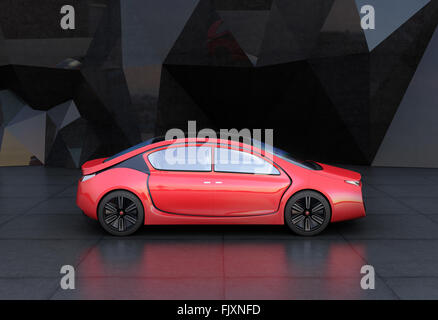 Side view of red autonomous car in front of geometric object background Stock Photo