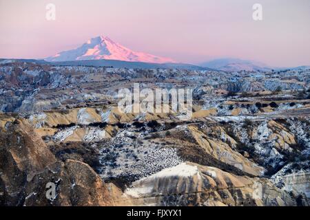 Snow covered volcanic 3916m peak of Mount Erciyes, highest mountain in central Anatolia Turkey. S.E. over gorges of Goreme. Dusk Stock Photo