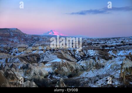 Snow covered volcanic 3916m peak of Mount Erciyes, highest mountain in central Anatolia Turkey. S.E. over gorges of Goreme. Dusk Stock Photo