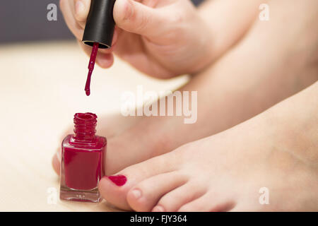 Self pedicure with red nail polish Stock Photo