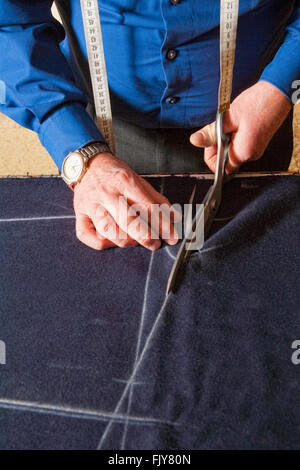Tailor Cutting Fabric to a New Coat with Scissors Stock Photo - Alamy