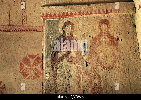 Early Christian mural. Saints, defaced gouged eyes, in rock carved Saint Barbara Church. Goreme National Park, Cappadocia Turkey Stock Photo