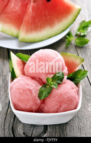 Watermelon sorbet ice cream in bowl on wooden background Stock Photo