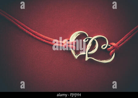 Two hearts connected, on red background. Stock Photo