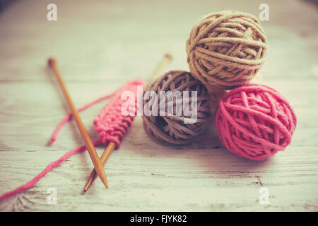 Balls of wool on wooden background, old retro vintage style Stock Photo