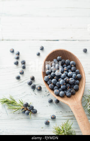 Wooden spoon with juniper berries Stock Photo