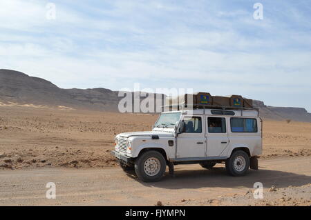Driving Land Rover Defender in Sahara Stock Photo