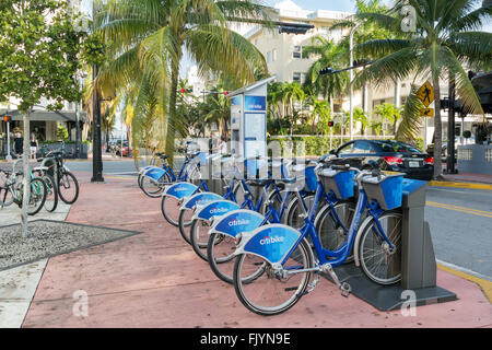 Bicycles parked in a row at city bike station on corner Collins Avenue and 14th Street in South Beach district of Miami Beach, F Stock Photo
