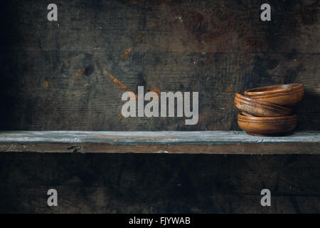 Old wooden bowls, placed on a wooden shelf Stock Photo