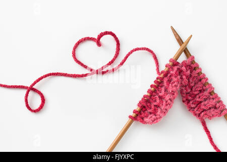 Incomplete knitting project with heart shaped woolen yarn Stock Photo