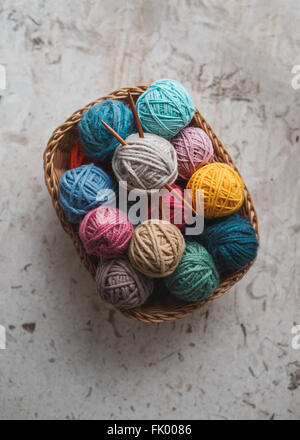 Knitting needles and yarn balls in basket Stock Photo
