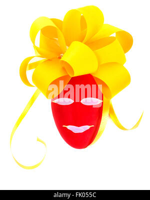 Closeup photo of beautiful decorated Easter egg isolated on white background, red egg with festive yellow bow and face on it Stock Photo