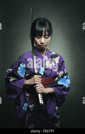 Samurai woman with katana sword . Studio dark shot Stock Photo