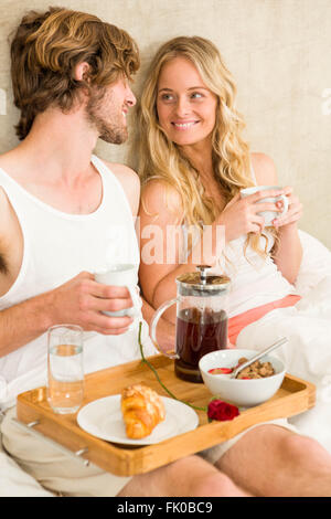 Cute couple having breakfast in bed Stock Photo