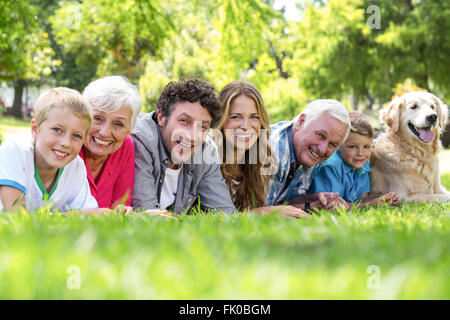 Family with dog lying on the grass in the park Stock Photo