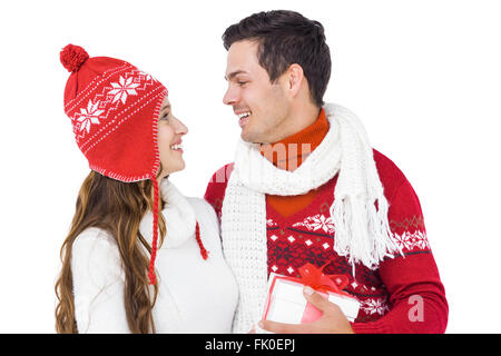 Happy couple with winter clothes holding gift box Stock Photo