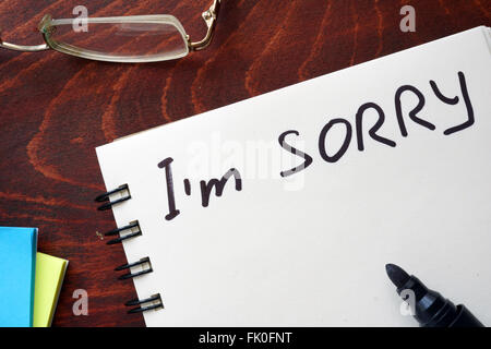 I am sorry written on notepad on a table. Stock Photo