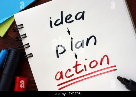 Idea, plan, action concept  written in a notebook on a wooden table. Stock Photo