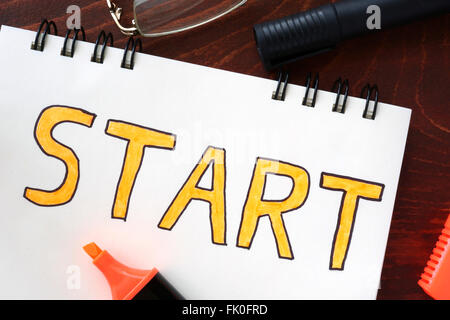 Start concept  written in a notebook on a wooden table. Stock Photo