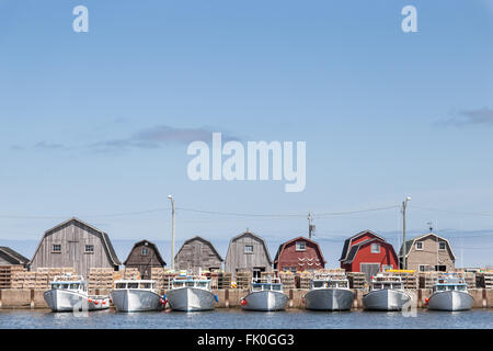 A line of fishing sheds and tied up fishing boats at Malpeque Harbour in Prince Edward Island (PEI) on the east coast of Canada. Stock Photo