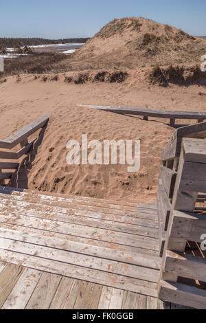Large pile of sand blocking a wooden boardwalk at Cavendish Beach, Prince Edward Island (PEI) on the east coast of Canada. There Stock Photo