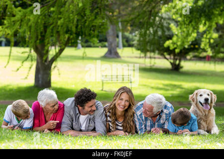 Family with dog lying on the grass in the park Stock Photo