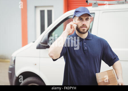 Delivery man making a phone call Stock Photo