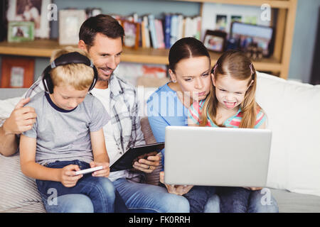 Family using technologies on sofa Stock Photo