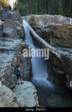 Female Hiker admiring Myra Falls in Strathcona Provincial Park near Campbell River, BC Stock Photo