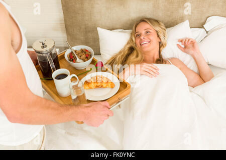 Cute man bringing breakfast to his girlfriend Stock Photo