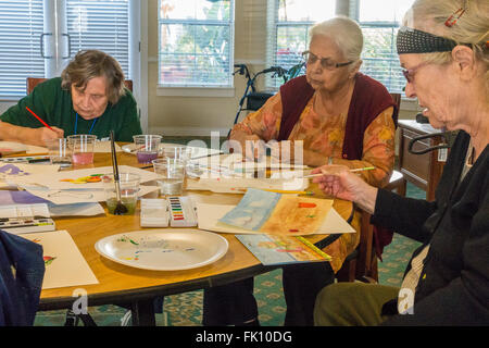 Female senior citizens paint in a watercolor class for seniors at Garden Court senior residence in Santa Barbara, California. Stock Photo