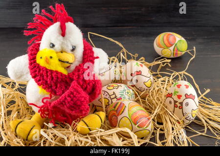 Decoupage decorated Easter eggs and family of toy chickens in a nest Stock Photo