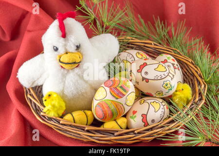 Decoupage decorated Easter eggs and family of toy chickens in a nest Stock Photo