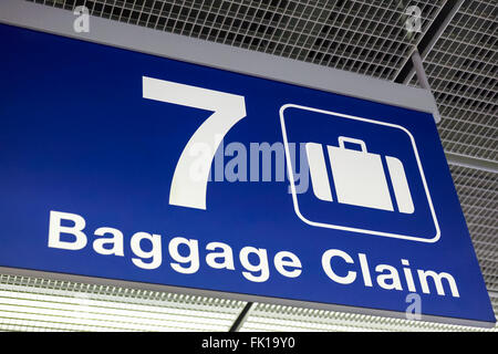 A blue airport baggage claim sign hanging from the ceiling Stock Photo