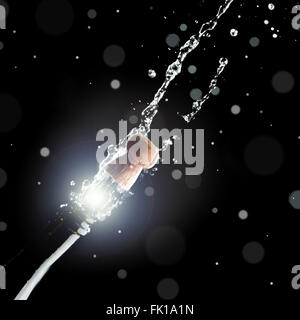 Champagne bottle with popping cork on black background Stock Photo