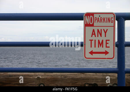 No parking sign on metal pipes in front of the sea Stock Photo
