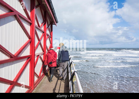 Saltburn by the sea, North Yorkshire, England, UK, 5th March 2016. Weather: well wrapped up for a Saturday stroll on Saltburn`s Victorian pier as an icy wind blows in off the cold North sea. Credit:  Alan Dawson News/Alamy Live News Stock Photo