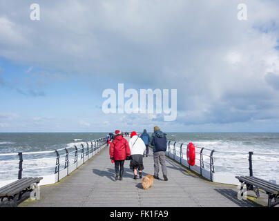 Saltburn by the sea, North Yorkshire, England, UK, 5th March 2016. Weather: well wrapped up for a Saturday stroll on Saltburn`s Victorian pier as an icy wind blows in off the cold North sea. Credit:  Alan Dawson News/Alamy Live News Stock Photo